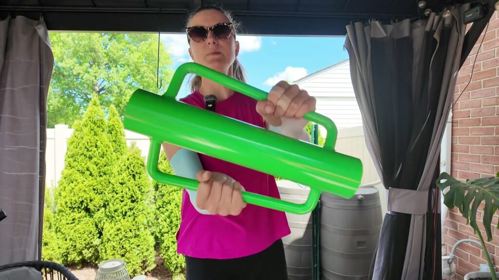 Woman holding a bright green T-post driver